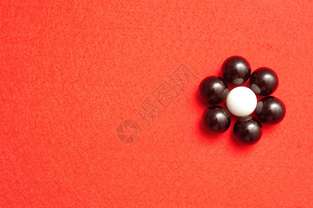 圆圈黑色的一种白和黑球以红背景孤立的花朵形状包装成白蛋和黑图片