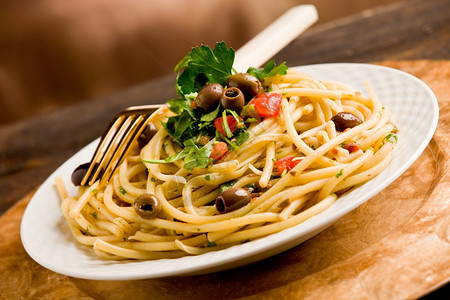 食物素主义者金的美味素食意大利面盘配有橄榄和木制餐桌上的欧斯利图片