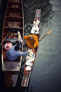 泰国冥想亚洲木船上的和尚从提供食物的妇女那里得到食物图片