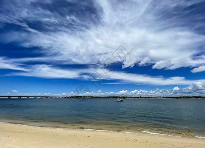 海滩多云的浮石Bribie岛与澳大利亚陆之间的狭窄水道称为PumicestonePassage南入口的景象图片