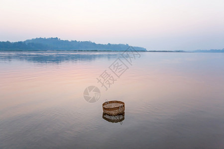 如画乡村的浸渍一条竹篮在冬季清晨的湄公河中浸泡日出天空照亮着温柔的水面北老挝农村的死灰复燃注背景图片