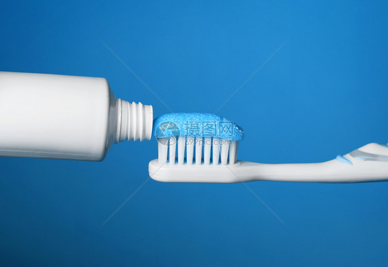 打扫有牙膏的刷贴上蓝底背景齿牙科图片