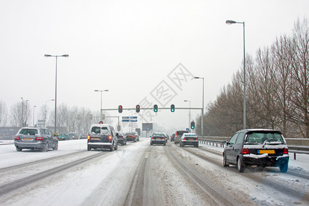 首都在荷兰冬季阿姆斯特丹的暴雪中驾车在荷兰城市街道图片