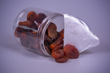 灰色的干燥背景塑料罐中干杏仁食物图片
