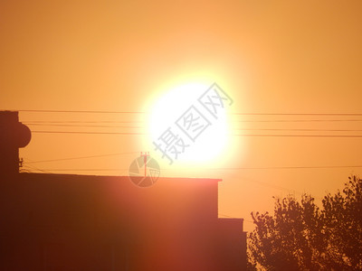 轮廓城市中太阳的黎明和房屋建筑结构的反射在城市中建造橙图片