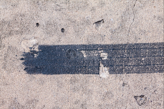灰色的混凝土路上铁轨轮胎刹车的黑色痕迹沥青质地图片