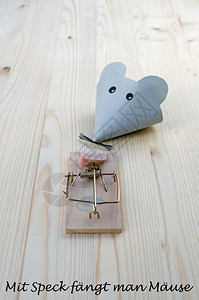 鼠由纸和捕器制成在木材上加培根和德国语作为好诱饵词的鼠标捕获小概念的抓住木制图片