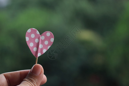 粉红圆点心的手持纸问候保空白的图片