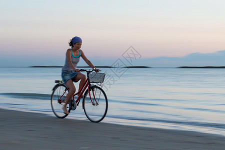 海边骑自行车的女孩背景图片