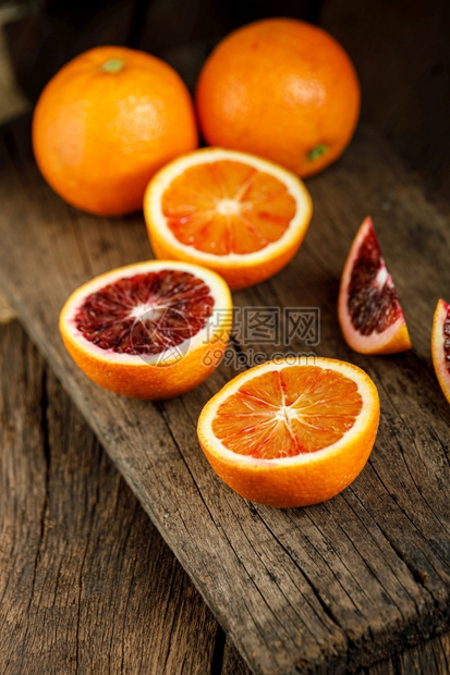 颜色古旧黑木本底的果实被切成西里血橙子柑橘切片图片
