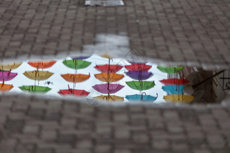 在街道伞状通上一个水坑中反射雨伞里戈建造一种图片