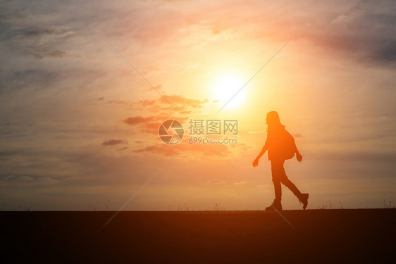 女士自由带着背包的爬山者放松和享受日落假期图片