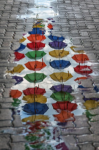 一种罗马尼亚在街道伞状通上一个水坑中反射雨伞景观图片