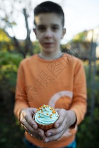 蓝色的花园男孩拿着蓝色松饼食物图片