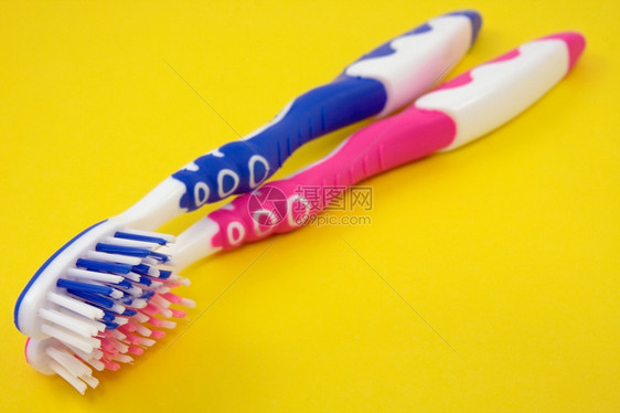 牙医刷子黄色背景上两个彩的牙刷卫生图片