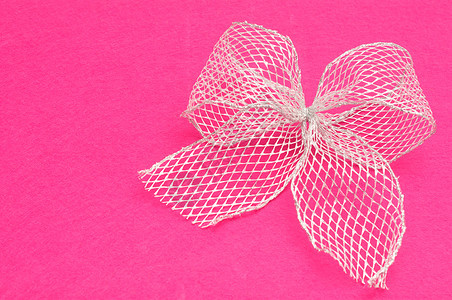 一种包裹庆典在粉红背景上被孤立的银弓图片