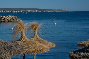 西班牙巴利阿里群岛Mallorca的蓝海和棕色草伞自然稻阳图片