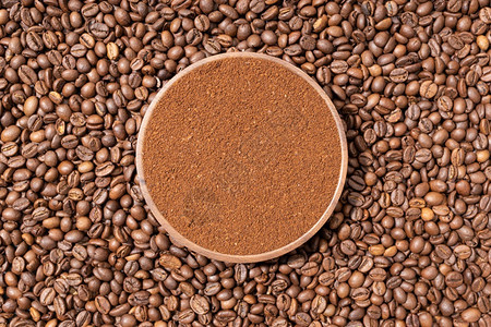 咖啡豆背景中的咖啡粉图片