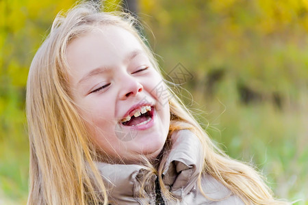 阳光下欢笑女孩的秋天肖像图片
