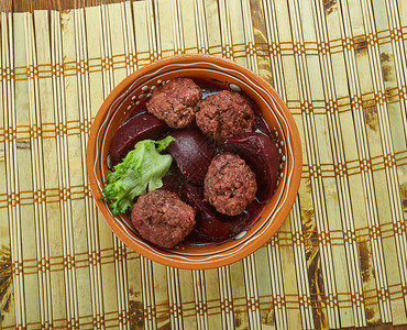 传统的伊拉克犹太菜盘土烤肉丸在生机勃的甜菜炖中结为牛排新鲜的晚餐图片