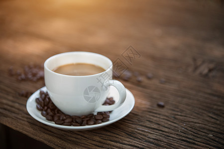 木桌上咖啡杯和咖啡豆图片