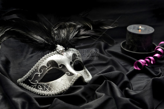 用蜡烛和丝带在深布背景的黑面上遮戴美丽的维尼蒂亚嘉年华面具化装舞会黑色的庆典图片