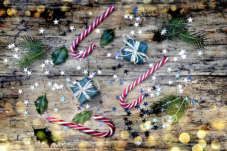 在糖果甘蔗和圣诞装饰上看天花板以彩色的面纱在生锈木背景上灯光模糊优质的假期冷杉图片