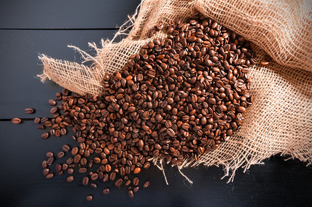 袋中散落的咖啡豆背景图片