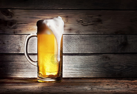 黑暗的小麦贮藏啤酒木制背景的轻啤酒高泡沫杯图片