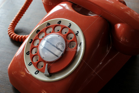 木制桌上旧的脏橙色电话经典的数字过去图片