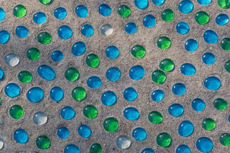 圆形的五彩缤纷白色蓝和绿沙尘玻璃珠的概述背景不规律的图片