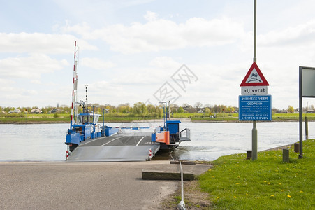 堤水支撑河流地貌的蓝色渡轮停靠在莱夫河边的登陆点图片