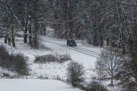 在联合王国北约克郡一辆雪覆盖车道上行驶的辆路天气冰图片