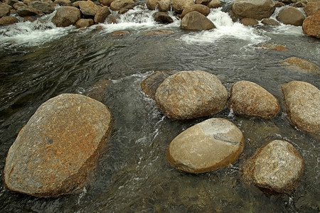 流动景观溪紧的石头和山洪中水图片
