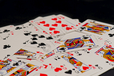 心赌女王在黑背景上孤立散乱布的打牌游戏卡图片