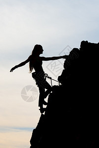 美丽的女孩身穿体质爬上岩石墙壁绳索锚征服图片