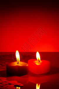 庆典红桌上两个燃烧的心形蜡烛圣诞节假期图片