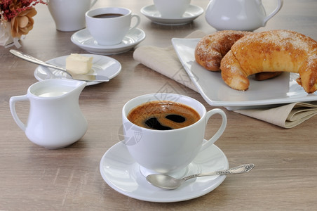 杯咖啡桌上加牛角面包奶油和午餐泡沫吃图片