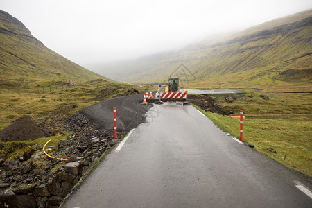 网站在职的法罗群岛道路建造工地有障标志和挖土机的路段标志和挖掘工地机图片