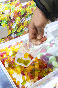 孩子可口儿童手从糖果店的展示品中摘果冻糖用贴上多彩的果美味图片