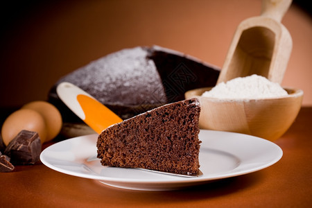 配料棕色的糕点照片美味巧克力蛋糕和棕色背景的成份照片图片