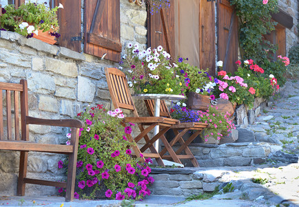 视窗在高山村一所房屋的外墙前摆着花朵和椅子盛放多彩鲜花阳台结石图片