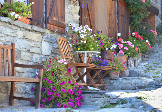 视窗在高山村一所房屋的外墙前摆着花朵和椅子盛放多彩鲜花阳台结石图片