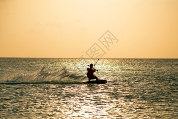 海人们日落时在加勒比阿鲁巴岛Aruba的Kite冲浪者男人图片