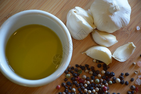 胡椒粒盘子烹饪大蒜和木剪板上的胡椒油在拉面盘中的橄榄油图片