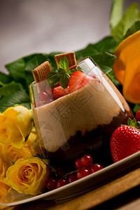 甜点在玫瑰背景前有浆果的巧克力栗子甜瓜摩丝可口图片