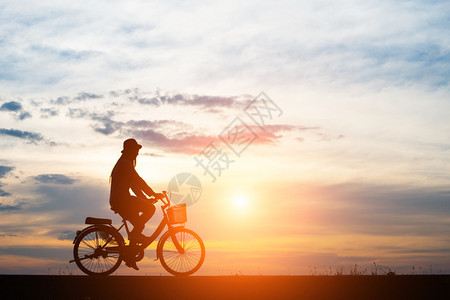 云阳光骑术年轻人在日落背景下骑自行车图片