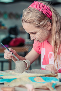 女孩在陶瓷车间做第一件陶器手艺术家工图片