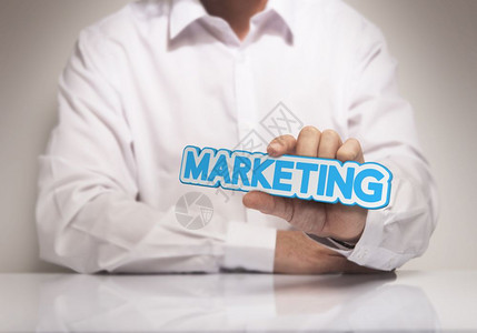 沟通机构男子手握着营销蓝色和蜜蜂调的词即展示营销解决方案的概念形象商业图片