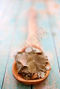 干燥香料木制勺子质树叶背景有选择焦点粉末图片